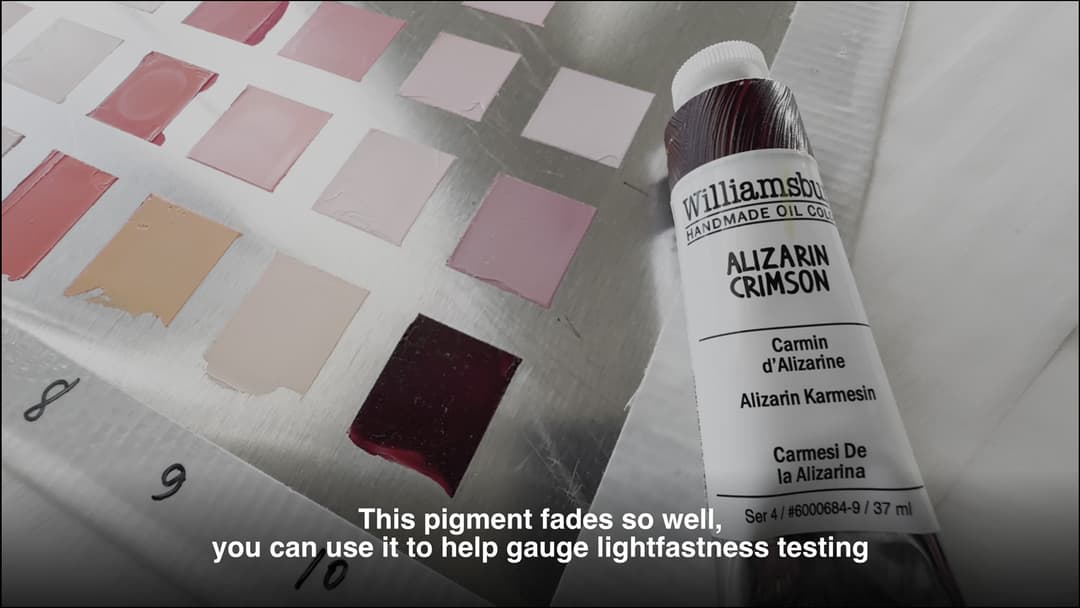 A tube of Alizarin Crimson next to an aluminum panel with squares of paint painted on it.
