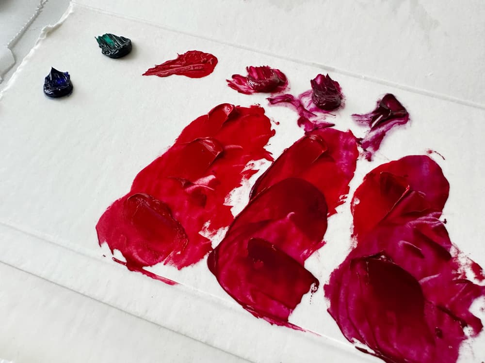 Three series of paint dollops show PR254 mixed with magentas to make the red deeper.