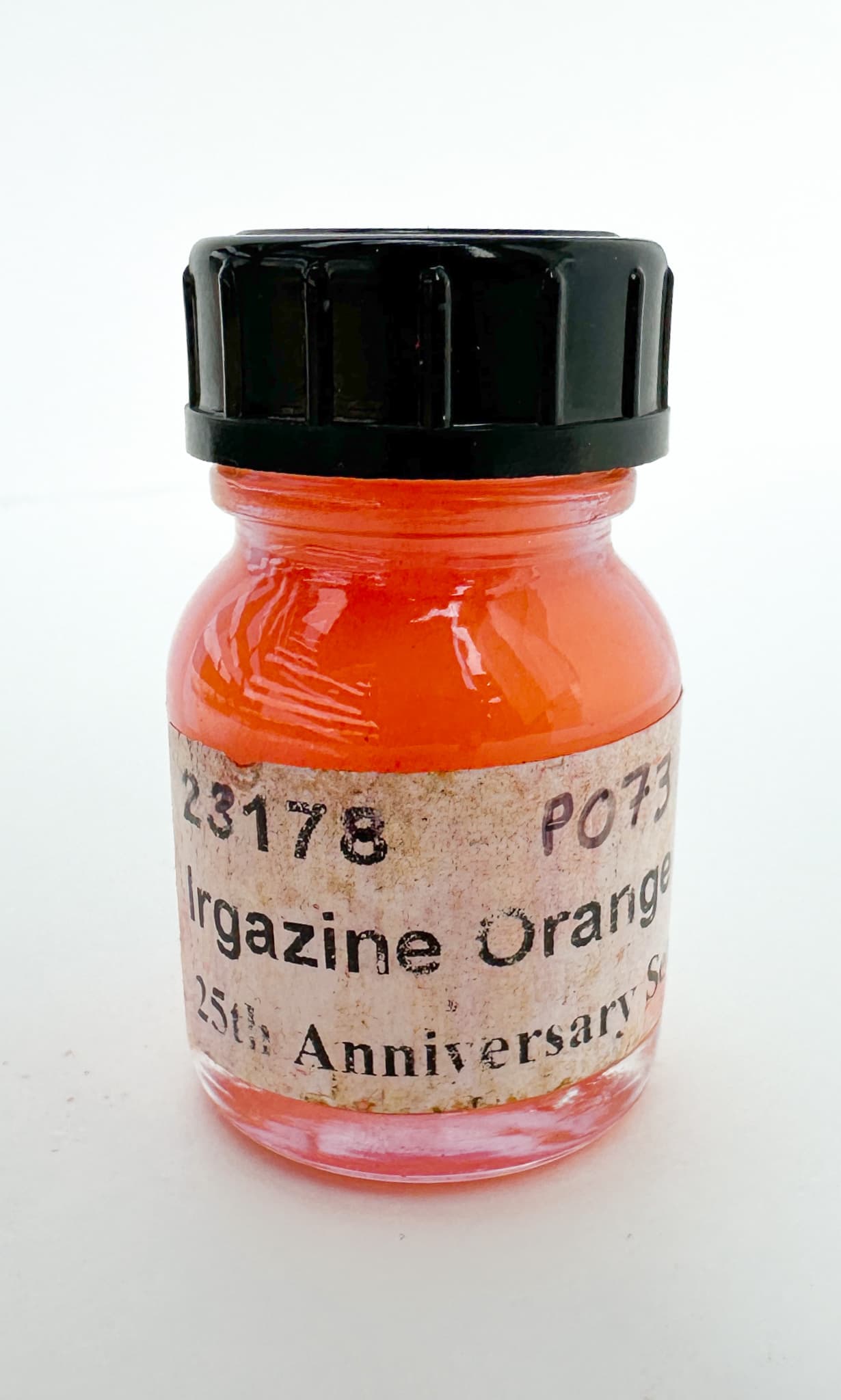 A bottle of orange dry pigment, PO73