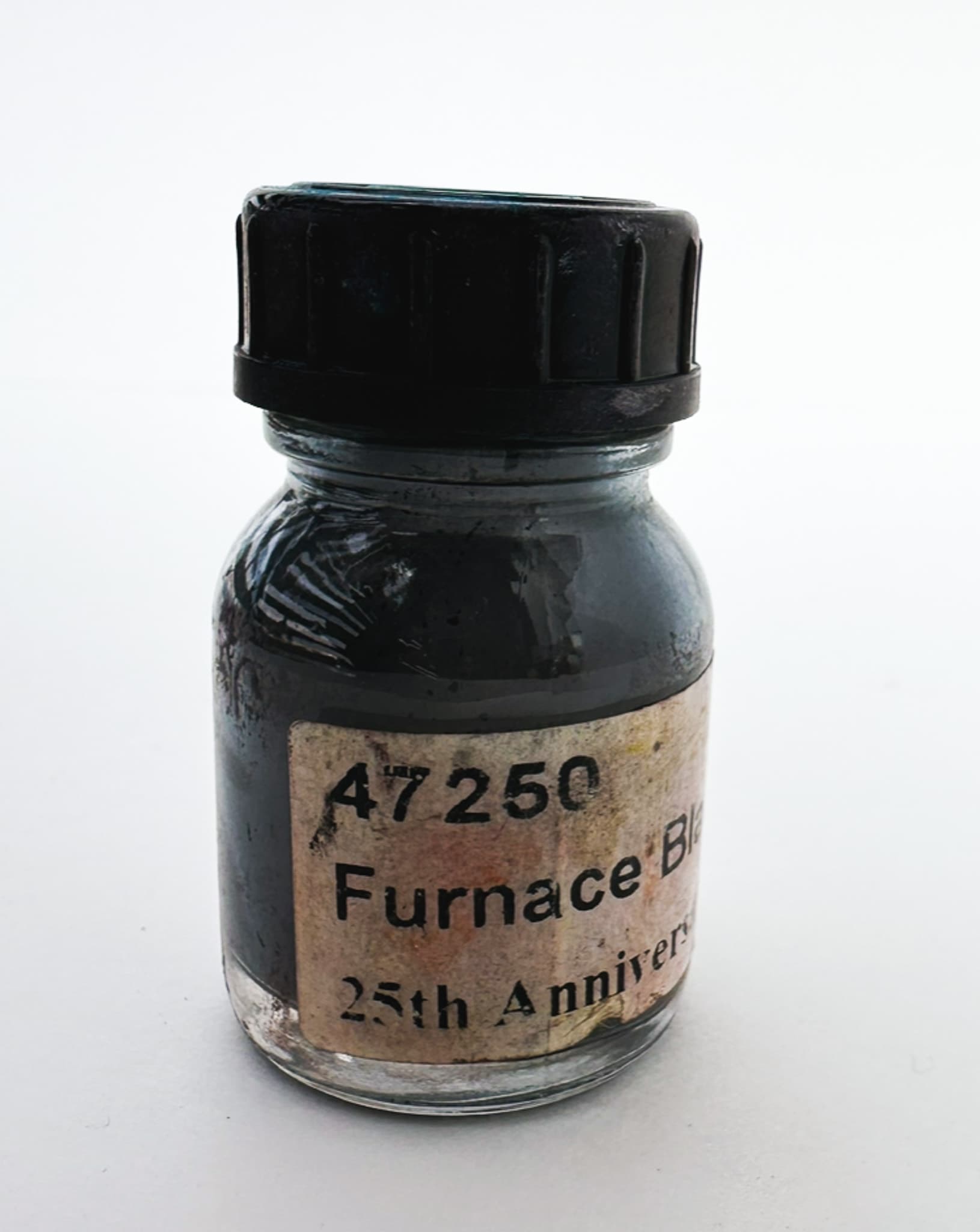 A worn bottle of black pigment