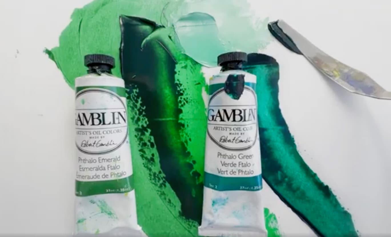 Two tubes of Gamblin oil paint with swatches of two different colors of green oil paint. While the greens are similar, the Phthalo Green Yellow Shade is a bit more of a yellow green while phthalo green blue shade is a bit more of a blue green.