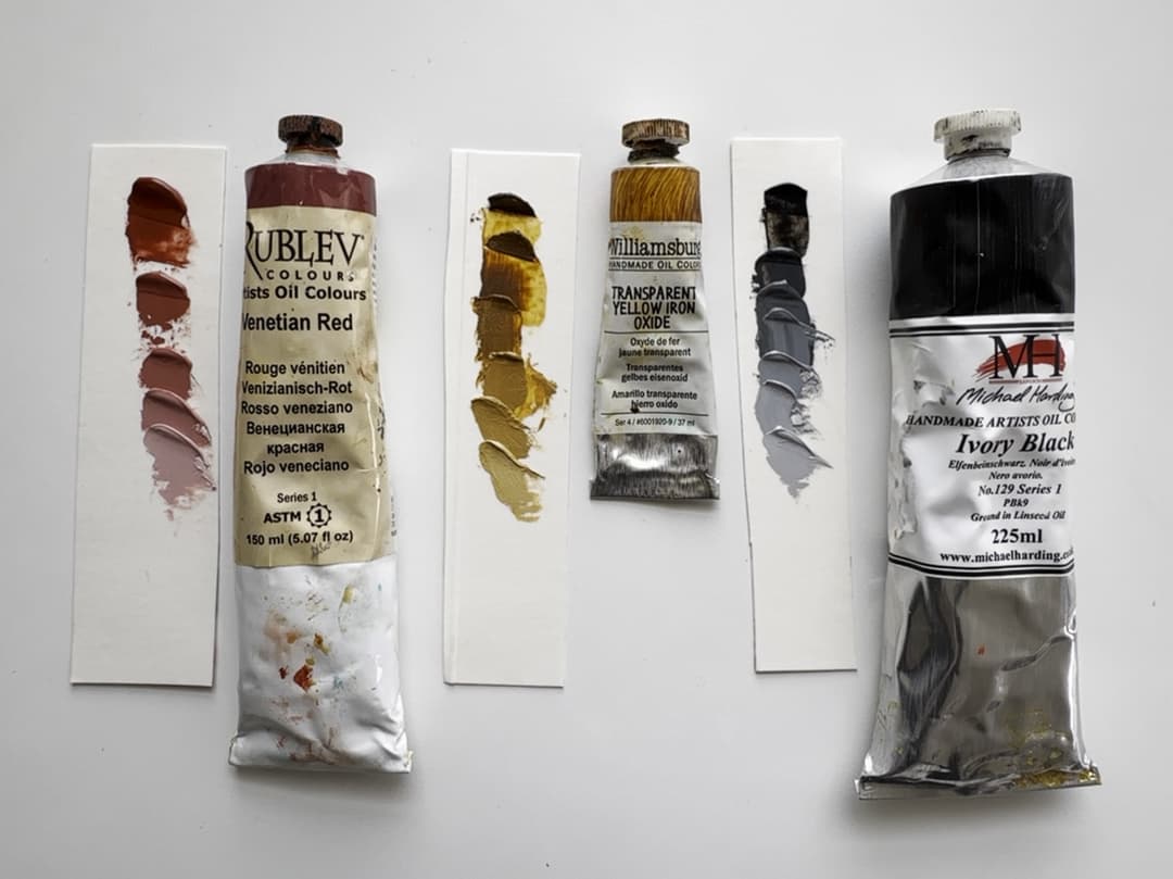 Three paint tubes with swatches of each paint mixed with white