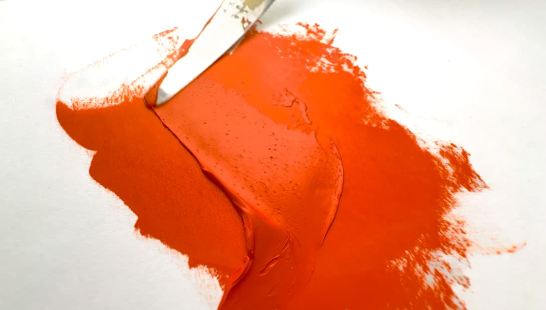 Orange oil paint moved by a palette knife