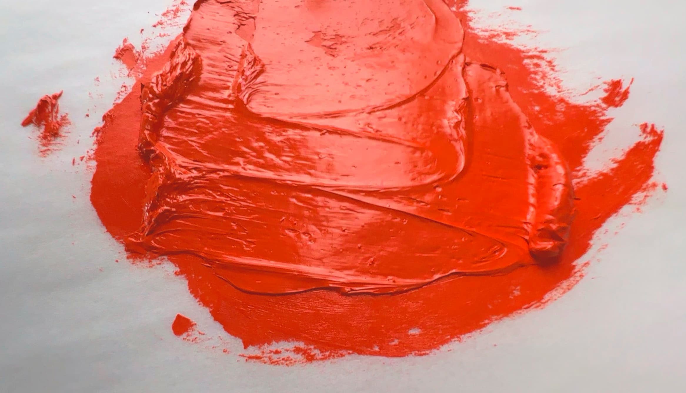 A swirl of orange oil paint made with PR104, chrome red