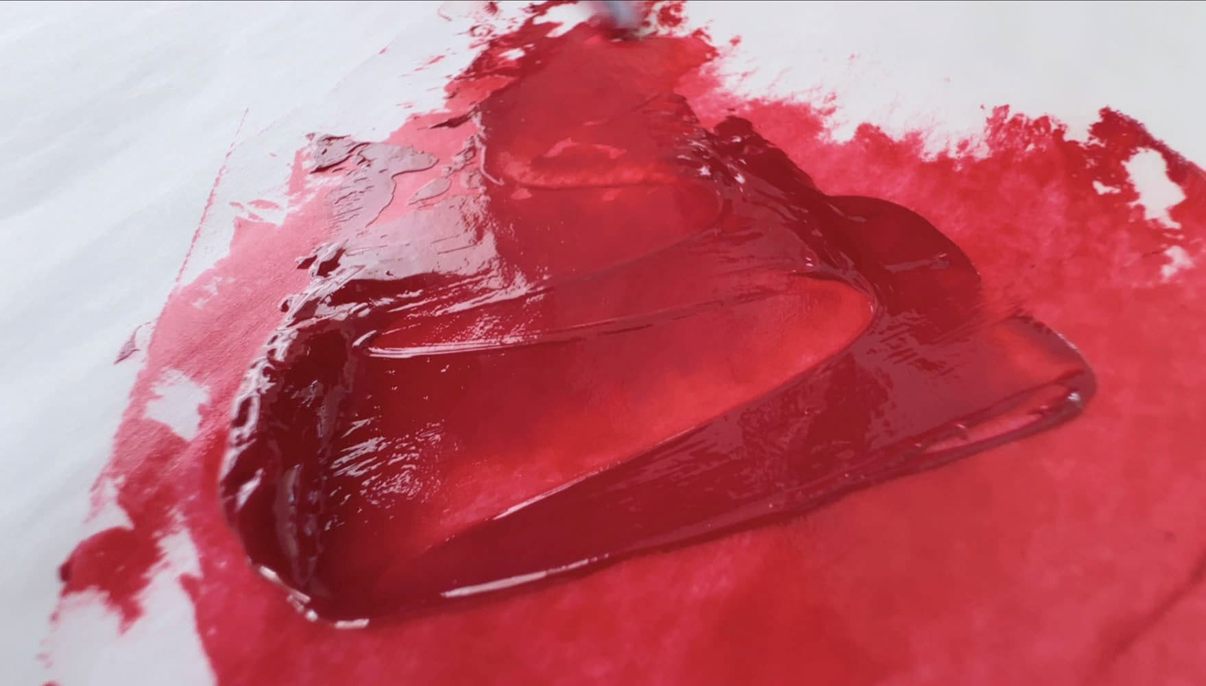 A swoosh of bright red transparent oil paint