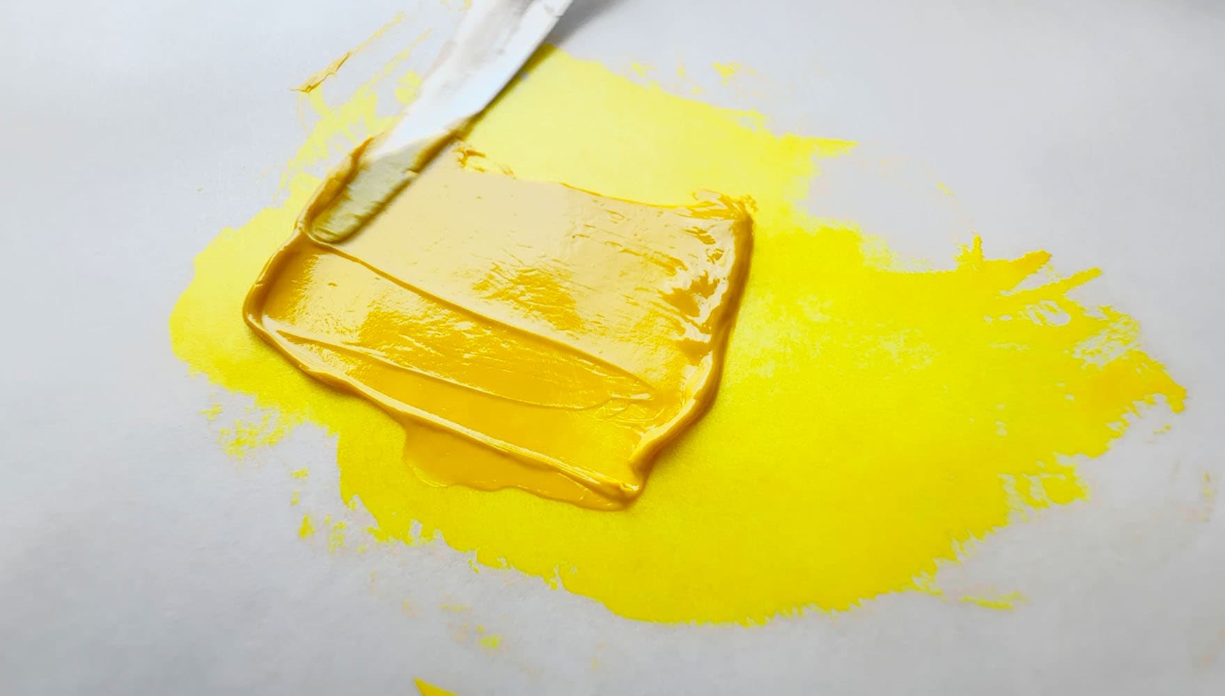 A daub of transparent yellow pulled by a palette knife