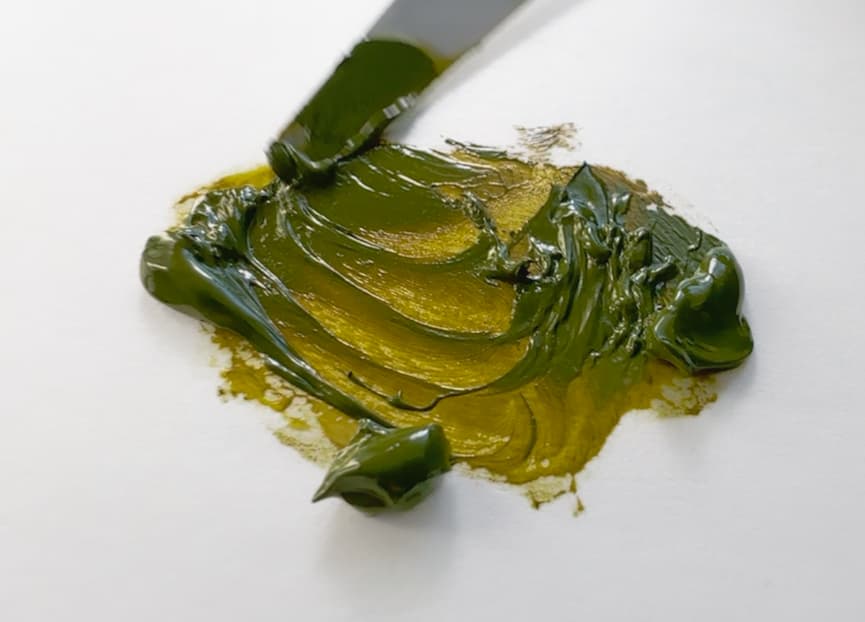 A dollop of oil paint which shows opacity and transparency where thin
