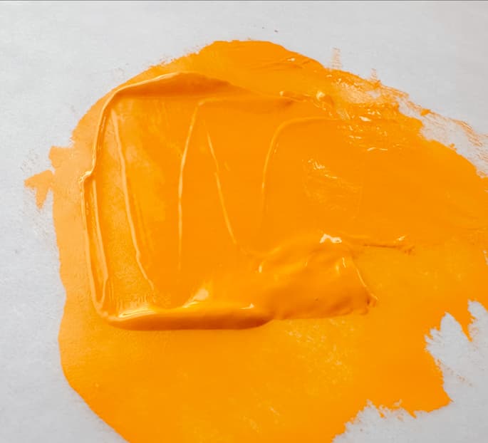 A swoosh of bright yellow orange oil paint with opacity. This is one of at least two types of Diarylide Yellow